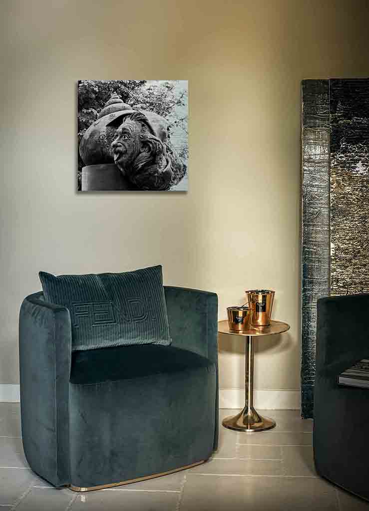 Ulm Einsteinbrunnen | Alu Dibond | #1050438 4 - 4 Ulmer Brunnenbild. Es zeigt das Bild einer Bronzeguss-Plastik von Albert Einstein. Die Seitenansicht seines Gesichts schaut mit herausgestreckter Zunge aus einem Schneckenhaus. Das Schneckenhaus wiederum liegt auf einem Raketenrumpf. Das Bild ist in den Farben Schwarz-Weiss. Das Bild hängt an einer stylische eingerichteten Wohnzimmerwand.