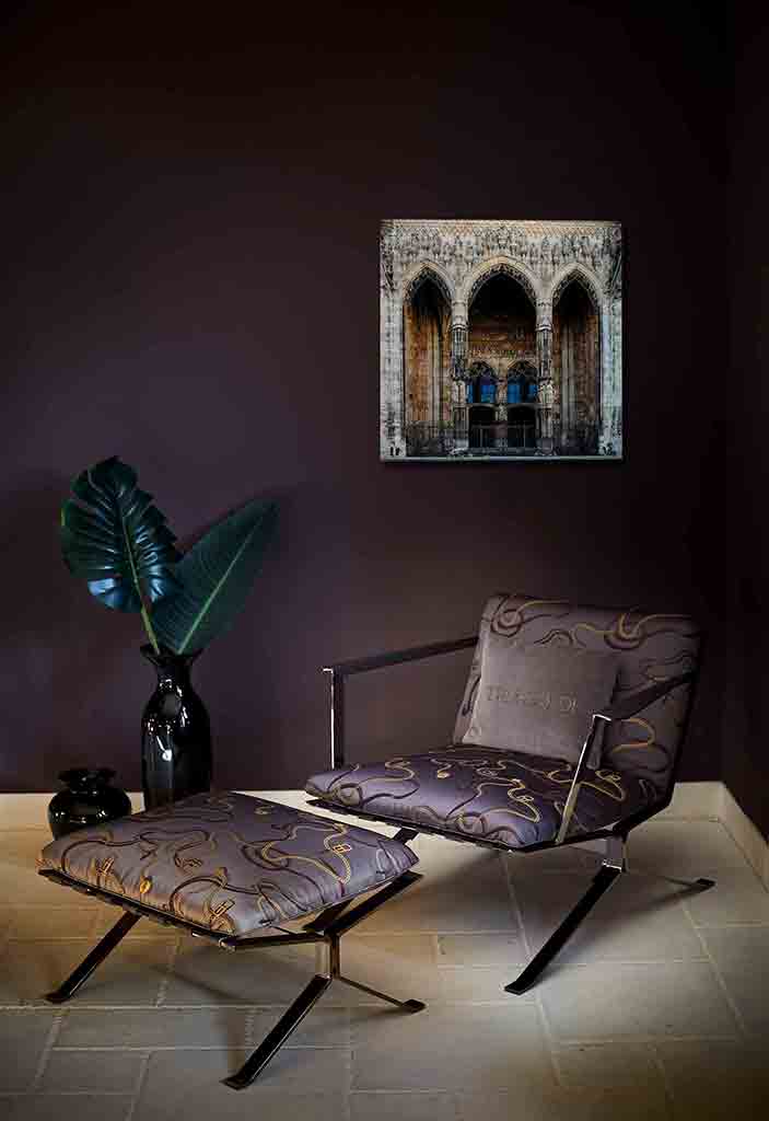 Ulm Münsterportal | Alu Dibond | #1150303-2 4 - 4 Hauptportal des Ulmer Münsters. Es zeigt das Bild des Hauptportals des Ulmer Münsters mit zwei großen Holztüren und zwei schön verzierte Säulen vor den Holztüren. Im und um das Portal wird mit verschiedenen Figuren und Darstellungen die Erschaffung der Welt erzählt. Das Bild ist farbig. Das Bild hängt an einer stylische eingerichteten Wohnzimmerwand.